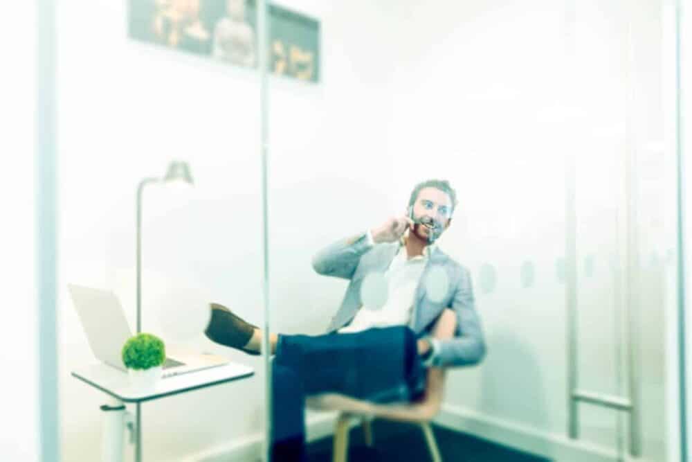 Corporate-photographer-mimecast-man-on-phone-in-glass-cubicle